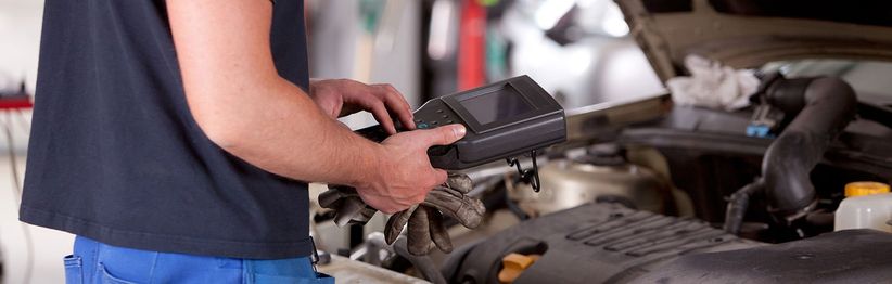 Es findet eine Überprüfung an einem Auto mittels Messgerät statt